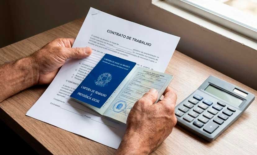 Trabalhador analisando contrato de trabalho e carteira profissional para verificar direitos de feriado